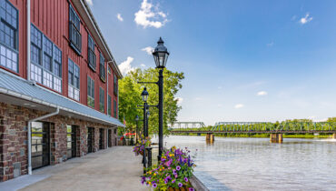 Quaint and colorful inn along a river on a sunny day.