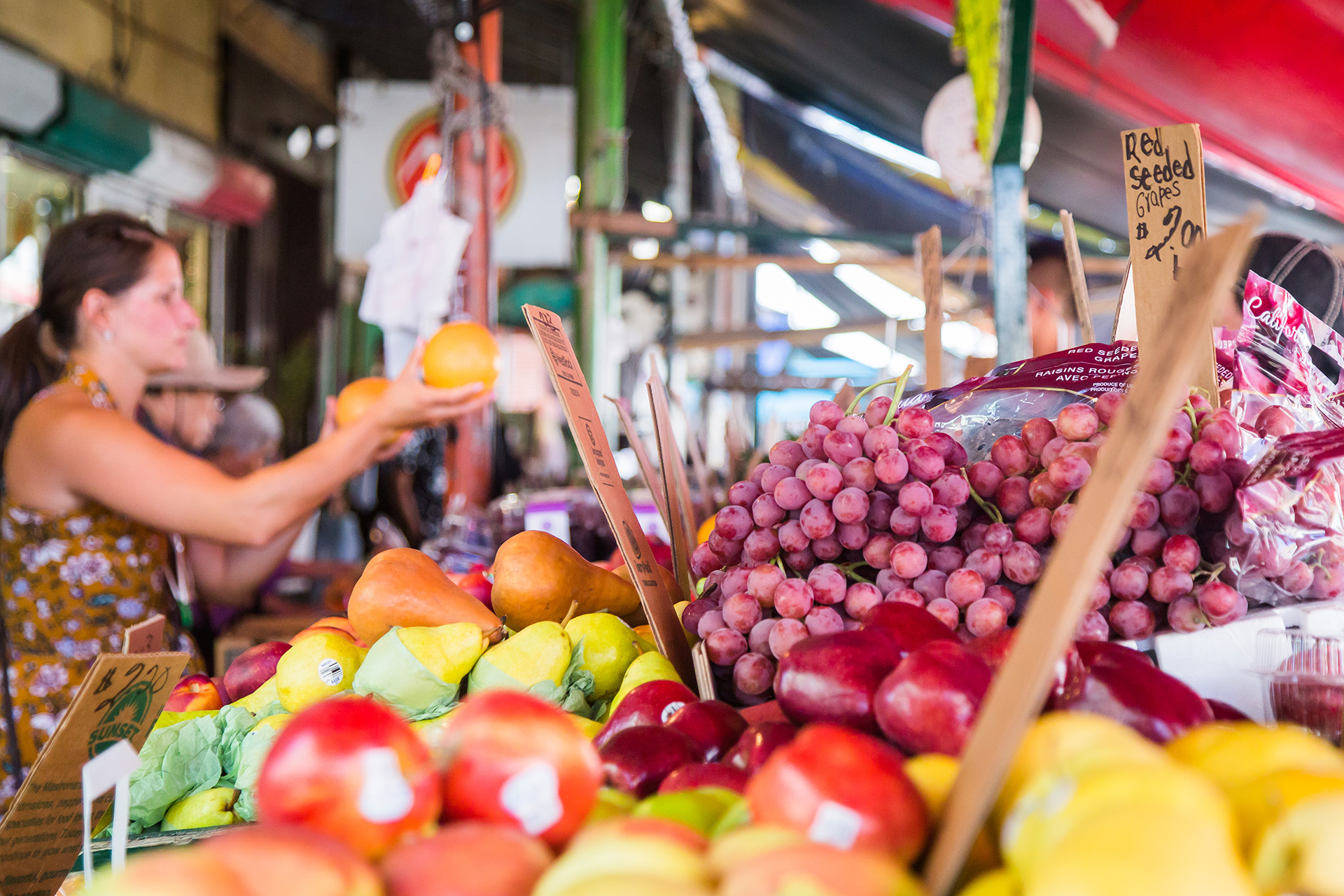 Woman comparing oranges at an outdoor Italian Market.