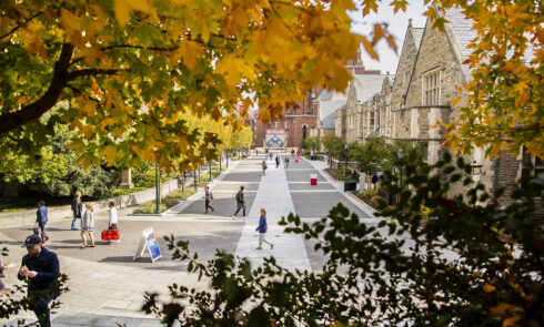 Students walk down a tree-lined pathway in the fall at University of Pennsylvania.