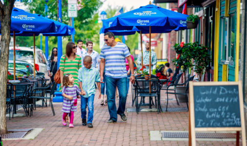 A young family of four strolls down a busy street in Philadelphia.