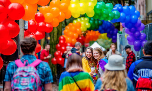 Two women pose for a picture together a a Pride festival.