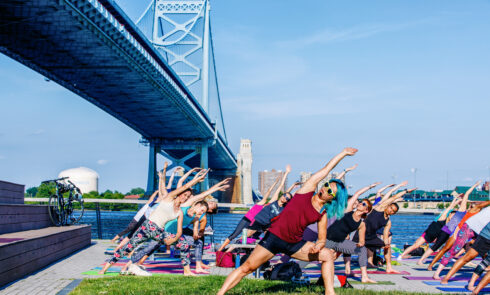 An outdoor yoga session on the riverbanks of Philadelphia.