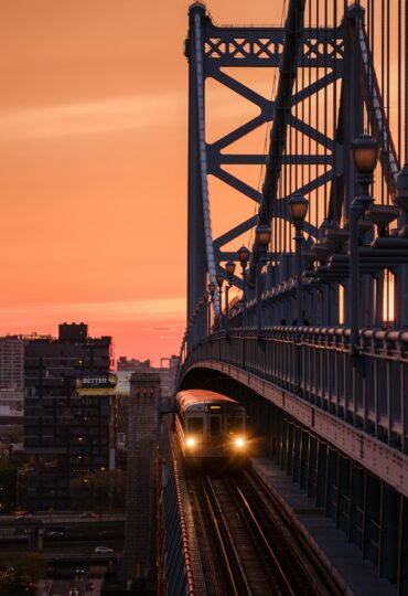 A train runs over a bridge at sunset in Philadelphia.