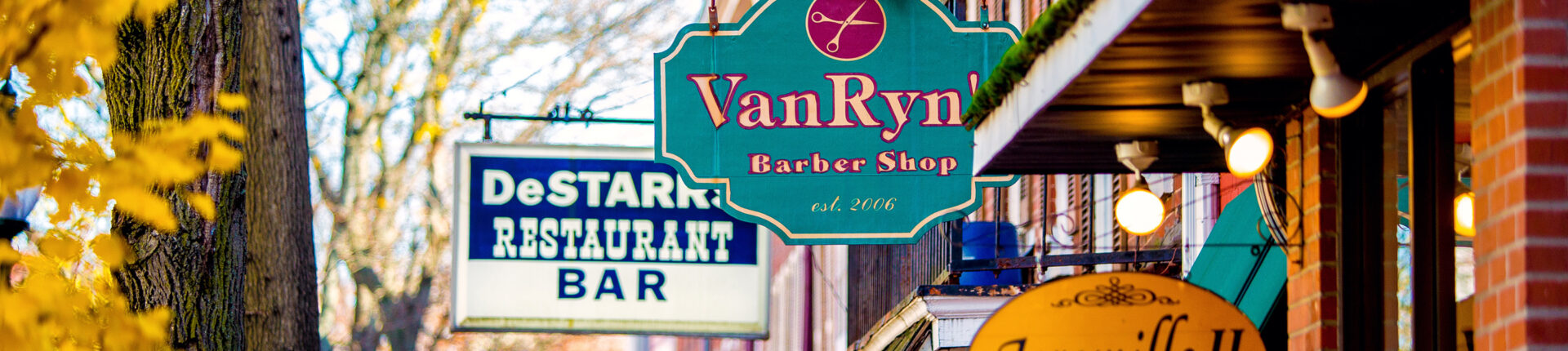 Colorful shop signs line a street in the fall.