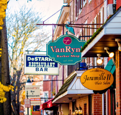 Colorful shop signs line a street in the fall.