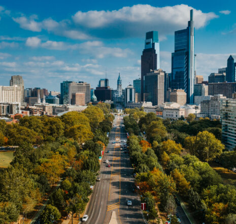 An aerial view of a tree-lined street leading to downtown Philadelphia.